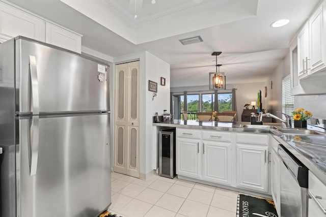 kitchen featuring sink, stainless steel refrigerator, dishwasher, beverage cooler, and hanging light fixtures