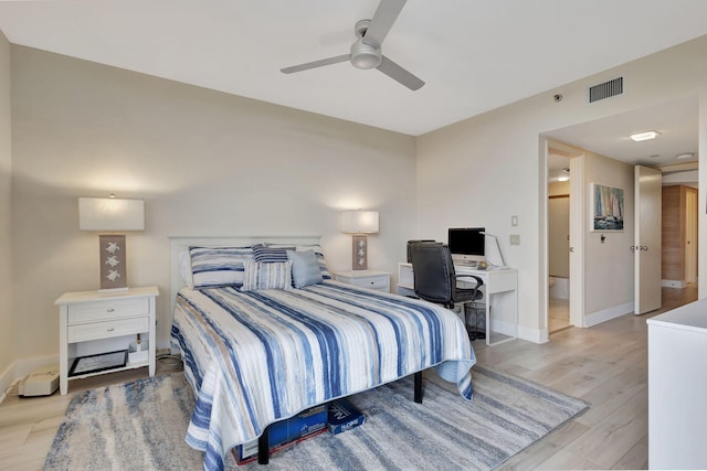 bedroom featuring light hardwood / wood-style floors, ceiling fan, and ensuite bathroom