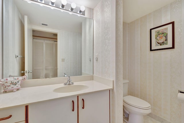 bathroom with tile patterned flooring, toilet, and vanity