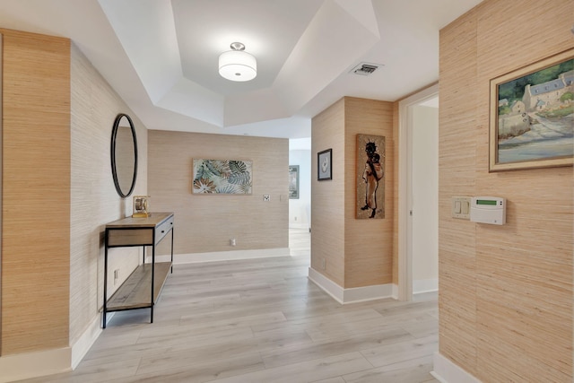 hall featuring a raised ceiling and wood-type flooring