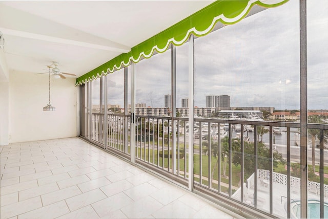 unfurnished sunroom with ceiling fan