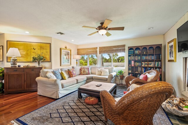 living room with dark hardwood / wood-style flooring and ceiling fan