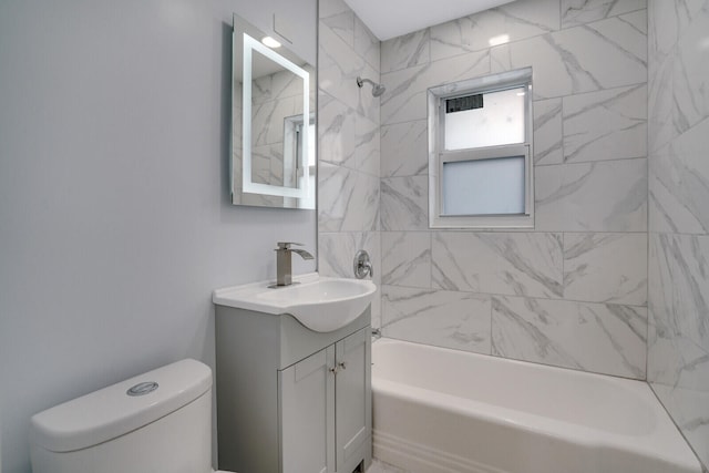 full bathroom featuring vanity, tiled shower / bath combo, and toilet