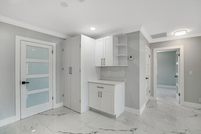 kitchen featuring light tile patterned flooring, backsplash, crown molding, and white cabinetry