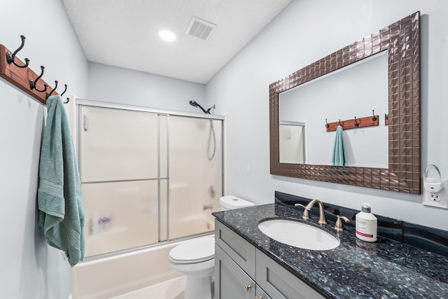 full bathroom with shower / bath combination with glass door, toilet, and vanity