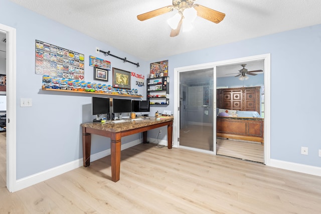 office area featuring light hardwood / wood-style flooring, ceiling fan, and a textured ceiling