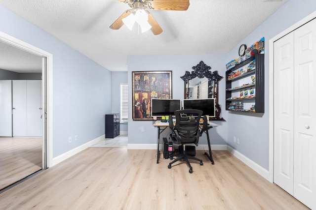 home office with ceiling fan, a textured ceiling, and light hardwood / wood-style flooring