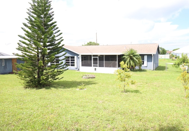 back of house with a sunroom and a yard