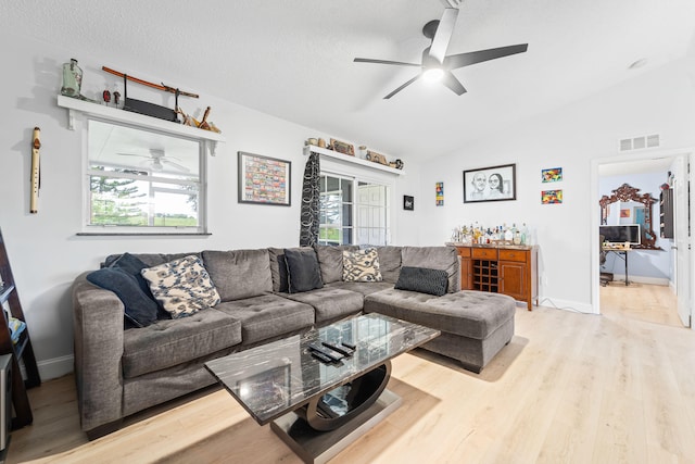 living room with light hardwood / wood-style flooring, vaulted ceiling, and a wealth of natural light