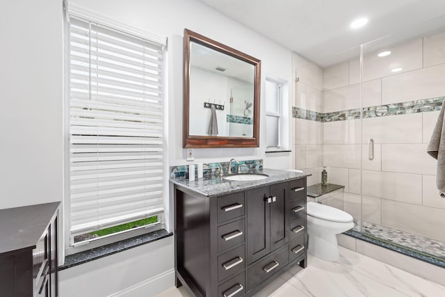 bathroom with vanity, toilet, and a shower with door