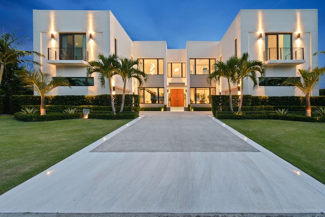 modern home with a front yard and a balcony