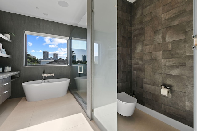 bathroom with plus walk in shower, tile patterned floors, vanity, and tile walls