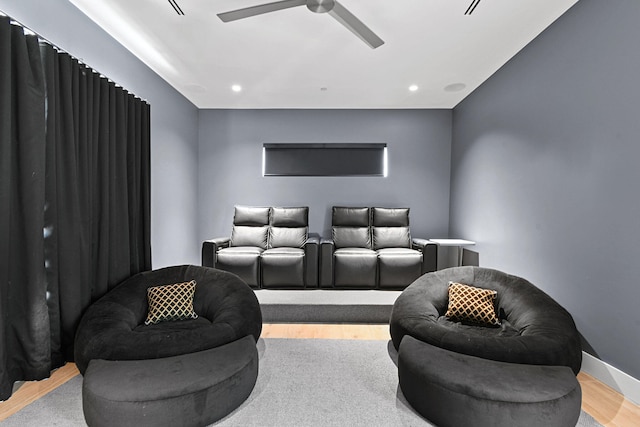 home theater room featuring light wood-type flooring and ceiling fan