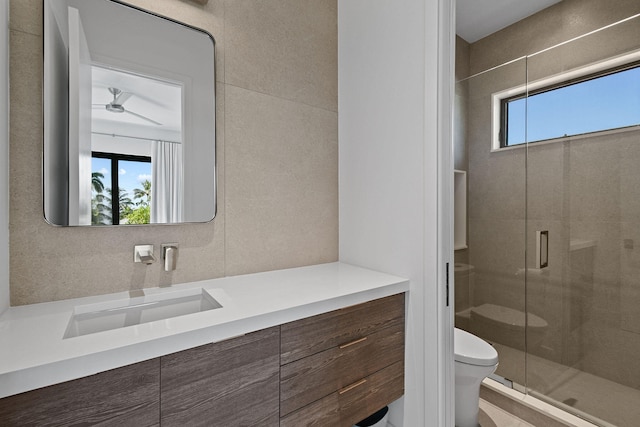 bathroom with walk in shower, vanity, plenty of natural light, and toilet