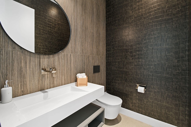 bathroom featuring vanity, tile walls, and toilet