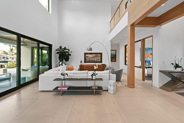 living room with beamed ceiling and a towering ceiling