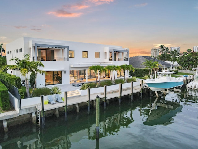 back house at dusk with a water view