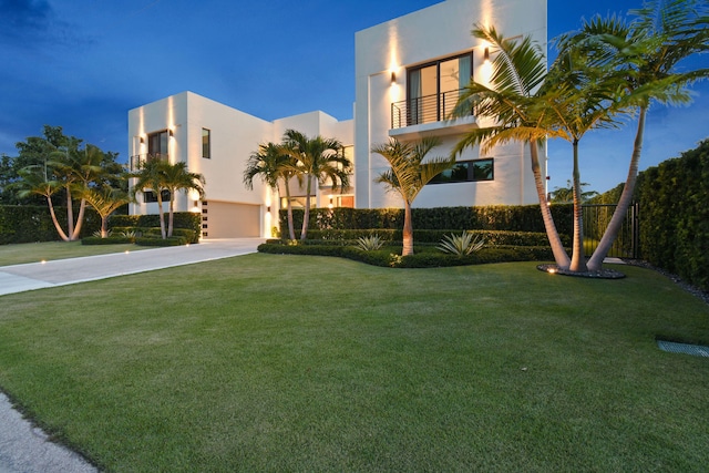 view of front facade with a balcony and a front lawn