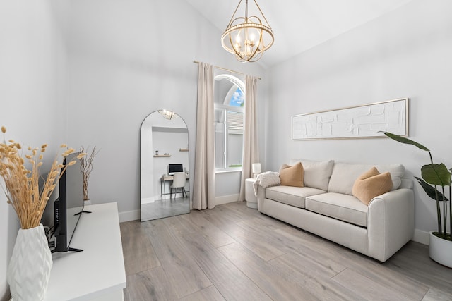 living room featuring light hardwood / wood-style floors, high vaulted ceiling, and a notable chandelier