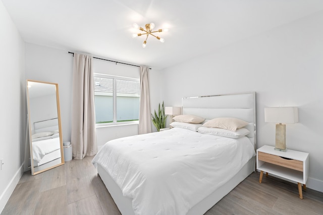 bedroom featuring light hardwood / wood-style floors and a chandelier