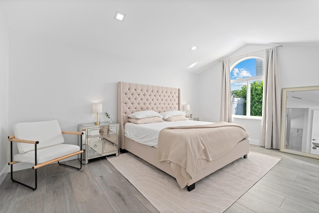 bedroom with light wood-type flooring and lofted ceiling