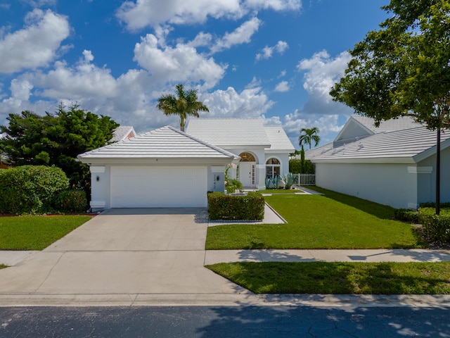 ranch-style home featuring a garage and a front lawn