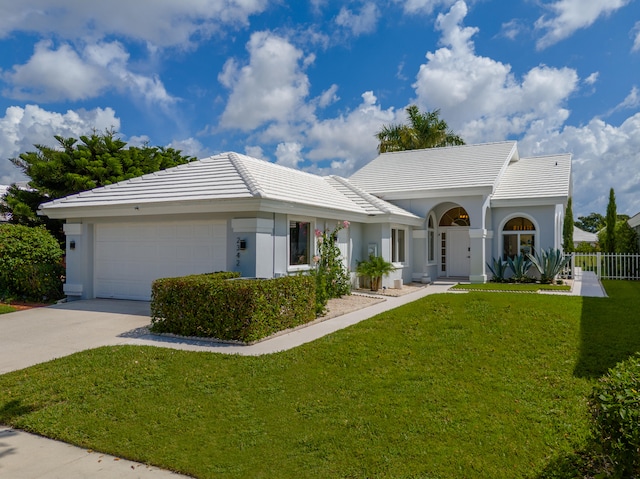 ranch-style home featuring a garage and a front yard