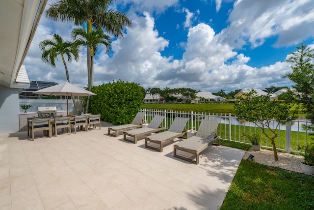 view of patio with an outdoor kitchen and a water view