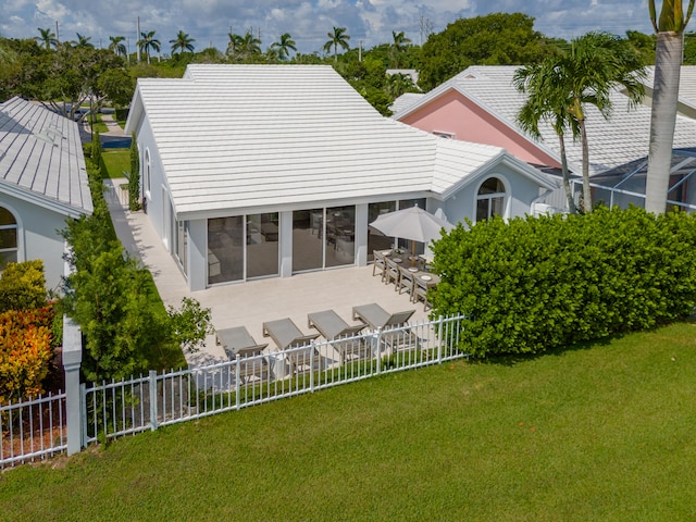 rear view of property with a lawn and a sunroom