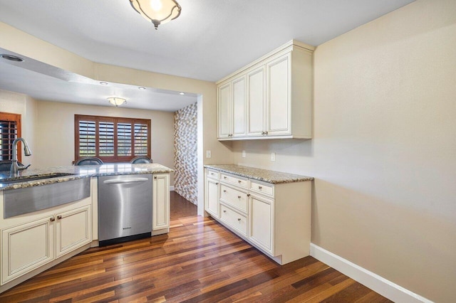 kitchen featuring a sink, dark wood-style floors, stainless steel dishwasher, and light stone countertops