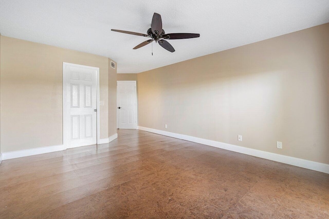 spare room with visible vents, ceiling fan, and baseboards