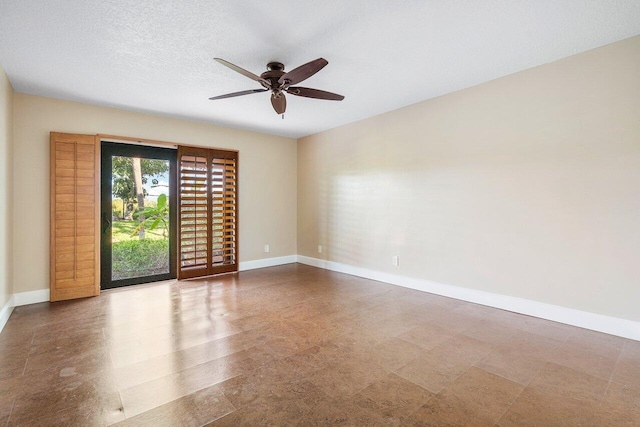 unfurnished room featuring ceiling fan, baseboards, and a textured ceiling