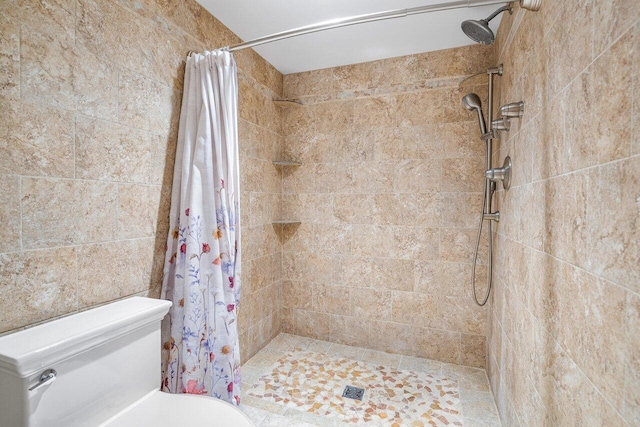 full bath with toilet and a stall shower