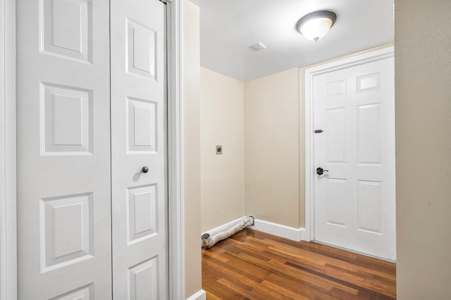 clothes washing area with dark wood-style floors, laundry area, electric dryer hookup, and baseboards