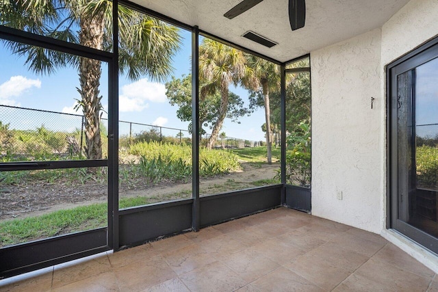 unfurnished sunroom featuring ceiling fan