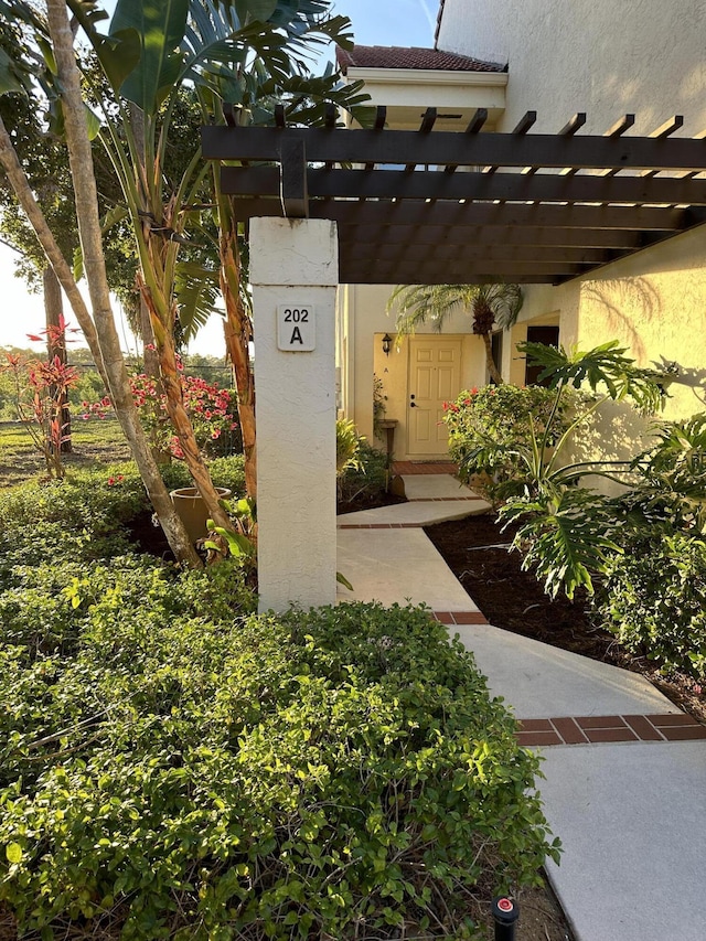 exterior space with stucco siding and a pergola