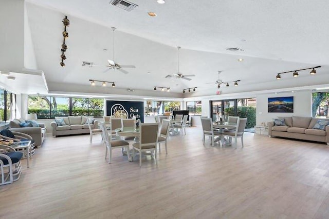 dining area featuring lofted ceiling, visible vents, and light wood-style flooring