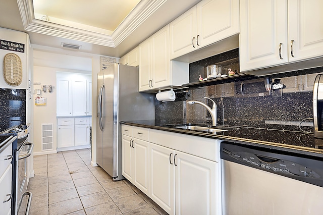 kitchen featuring a tray ceiling, white cabinets, stainless steel dishwasher, and sink