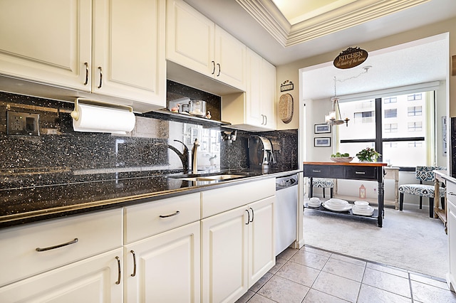 kitchen featuring stainless steel dishwasher, tasteful backsplash, sink, white cabinets, and light tile patterned floors