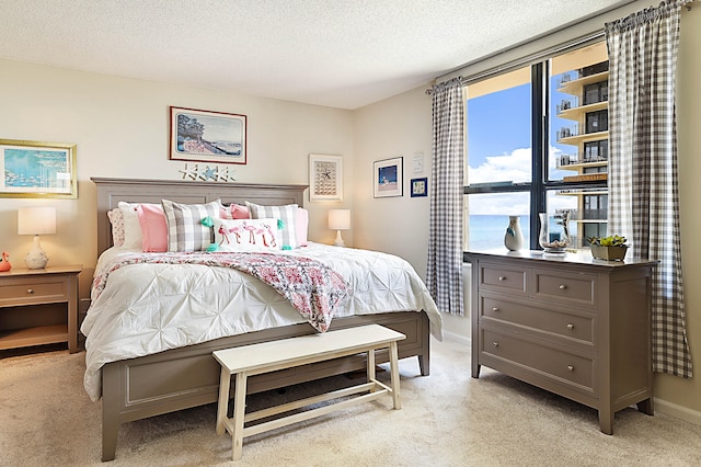 carpeted bedroom with a textured ceiling and a water view