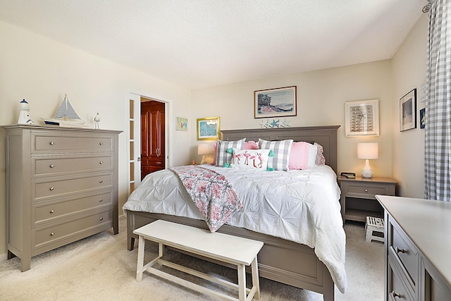 bedroom featuring light carpet and a textured ceiling