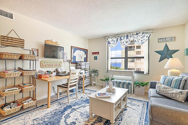 living room with a textured ceiling and light colored carpet