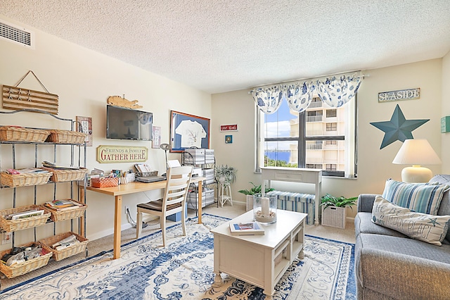 home office with light carpet, baseboards, visible vents, and a textured ceiling