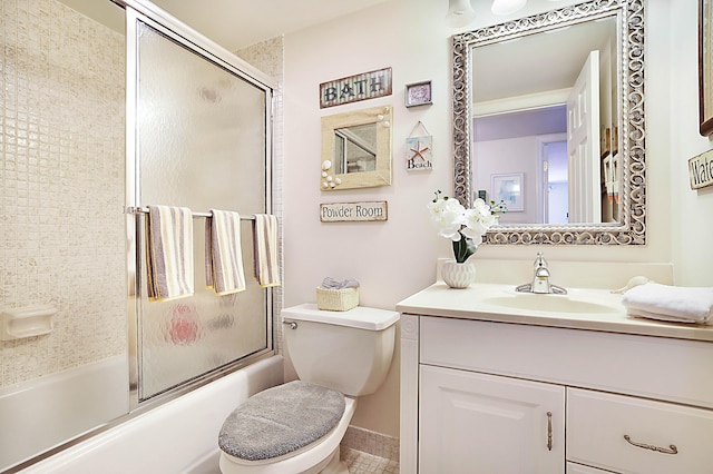 bathroom with toilet, combined bath / shower with glass door, and vanity