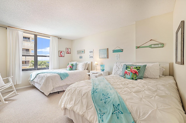 carpeted bedroom featuring baseboards and a textured ceiling