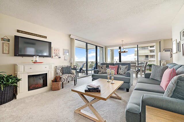 living room featuring an inviting chandelier, light colored carpet, and a textured ceiling