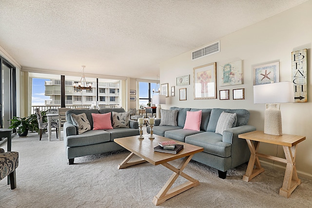 living room featuring a textured ceiling, light carpet, and a chandelier