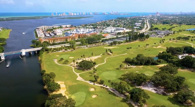 drone / aerial view with view of golf course, a water view, and a city view