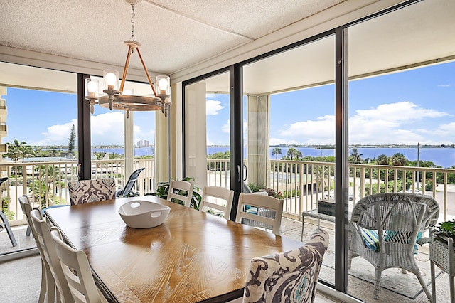 dining area featuring a wall of windows, a water view, and an inviting chandelier