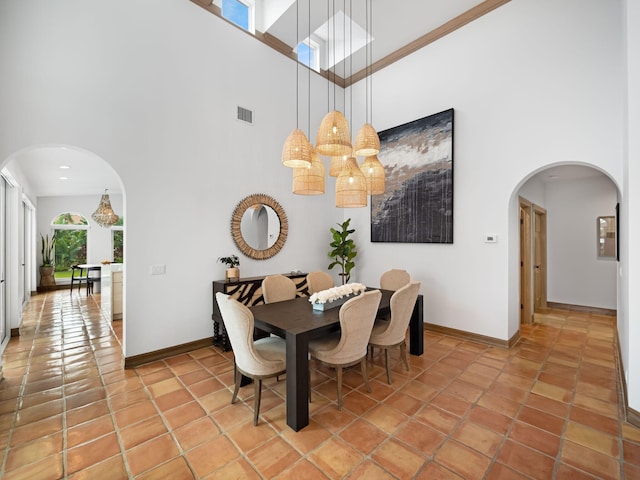 dining room with tile patterned flooring and a high ceiling